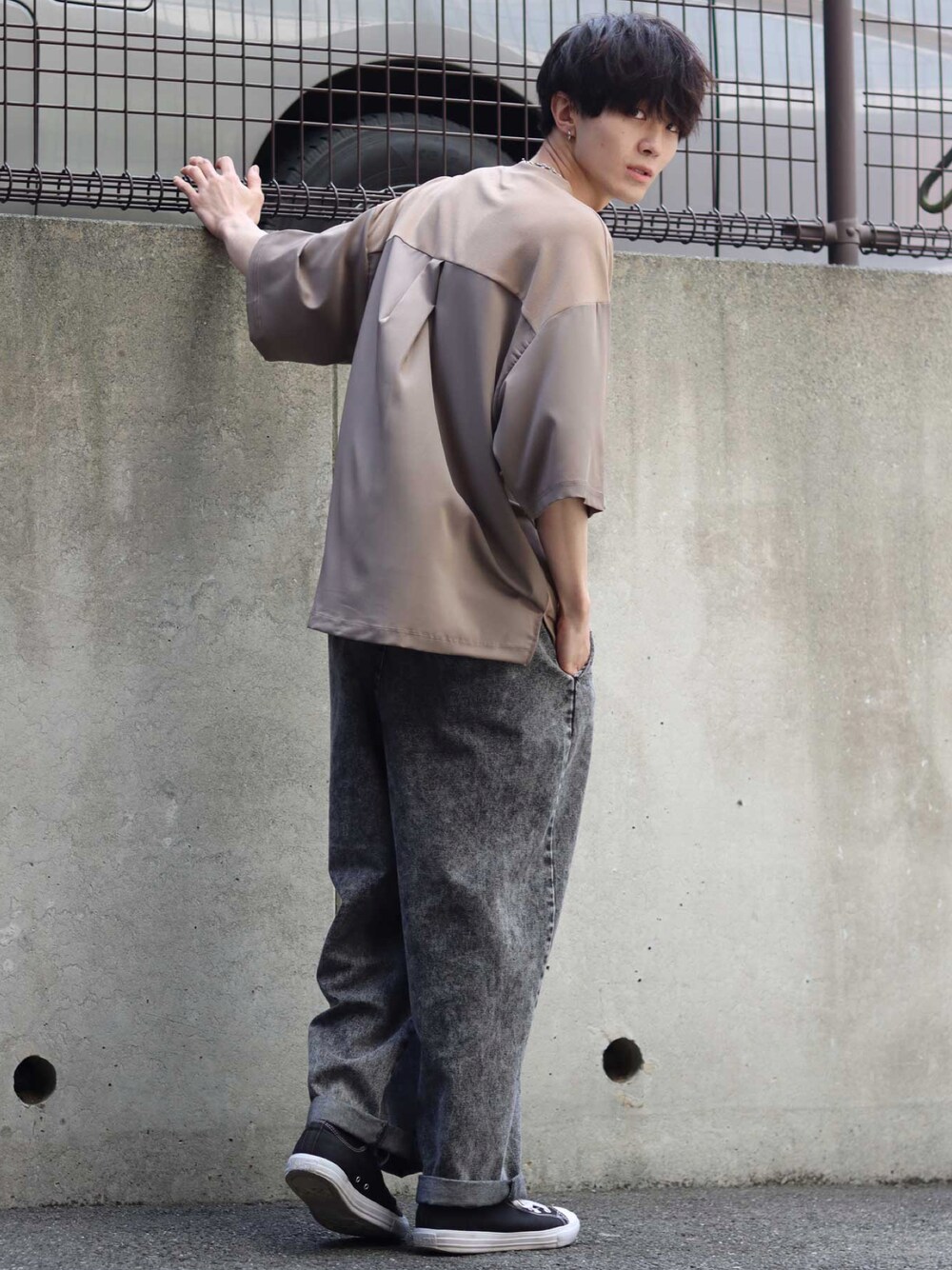 ベージュ系のTシャツ/カットソー、ブラック系のデニムパンツ、ブラック系のスニーカーを着用したメンズの春コーディネートの1枚目の写真