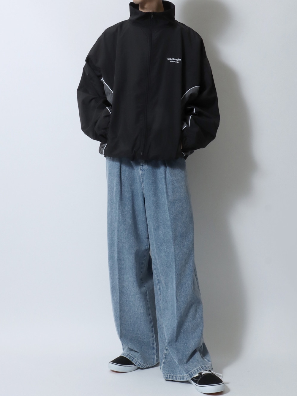 ブラック系のナイロンジャケット、ブルー系のデニムパンツ、ブラック系のスニーカーを着用したメンズの冬コーディネートの1枚目の写真