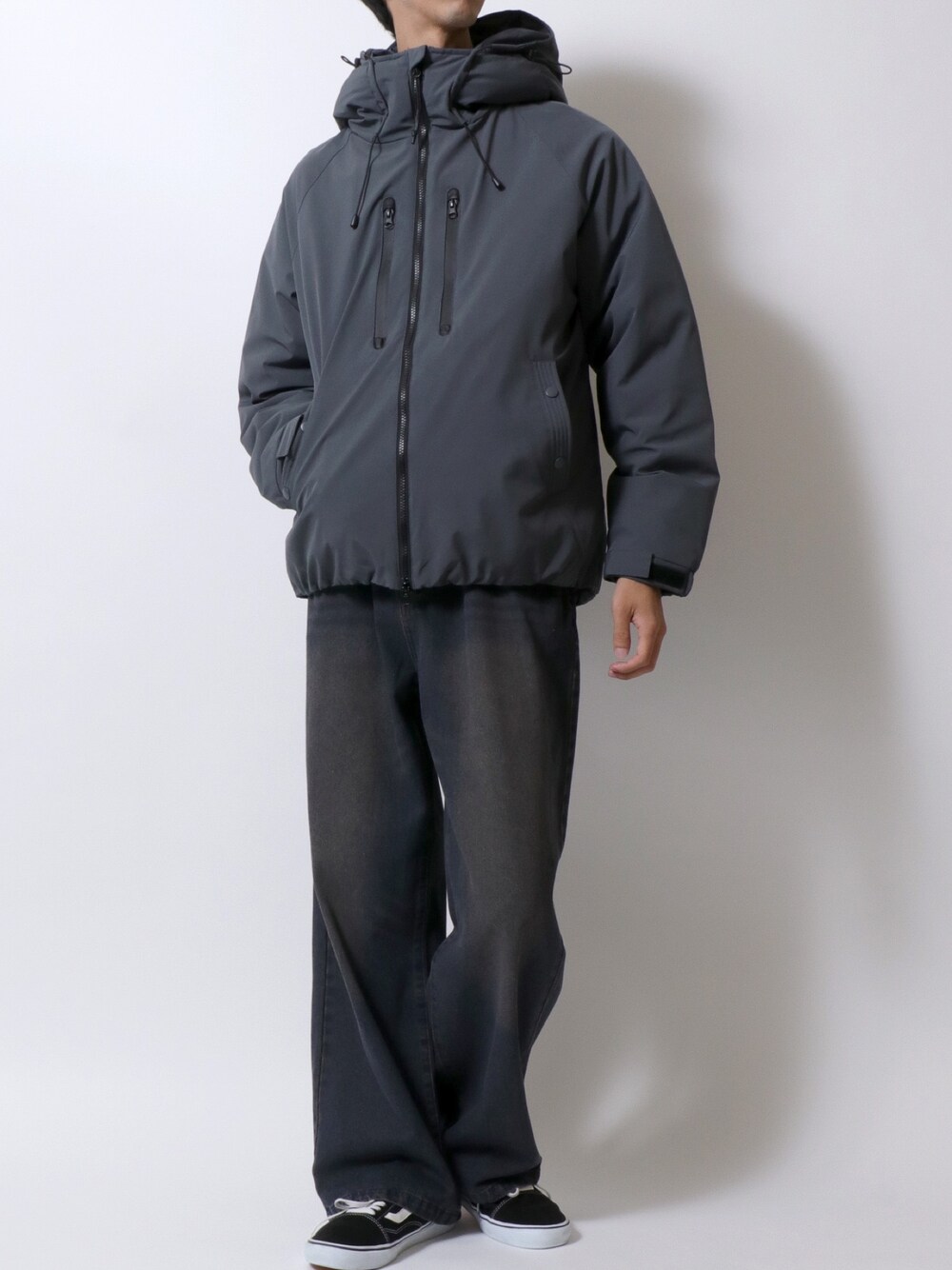 グレー系のダウンジャケット/コート、ブルー系のデニムパンツ、ブラック系のスニーカーを着用したメンズの冬コーディネートの1枚目の写真