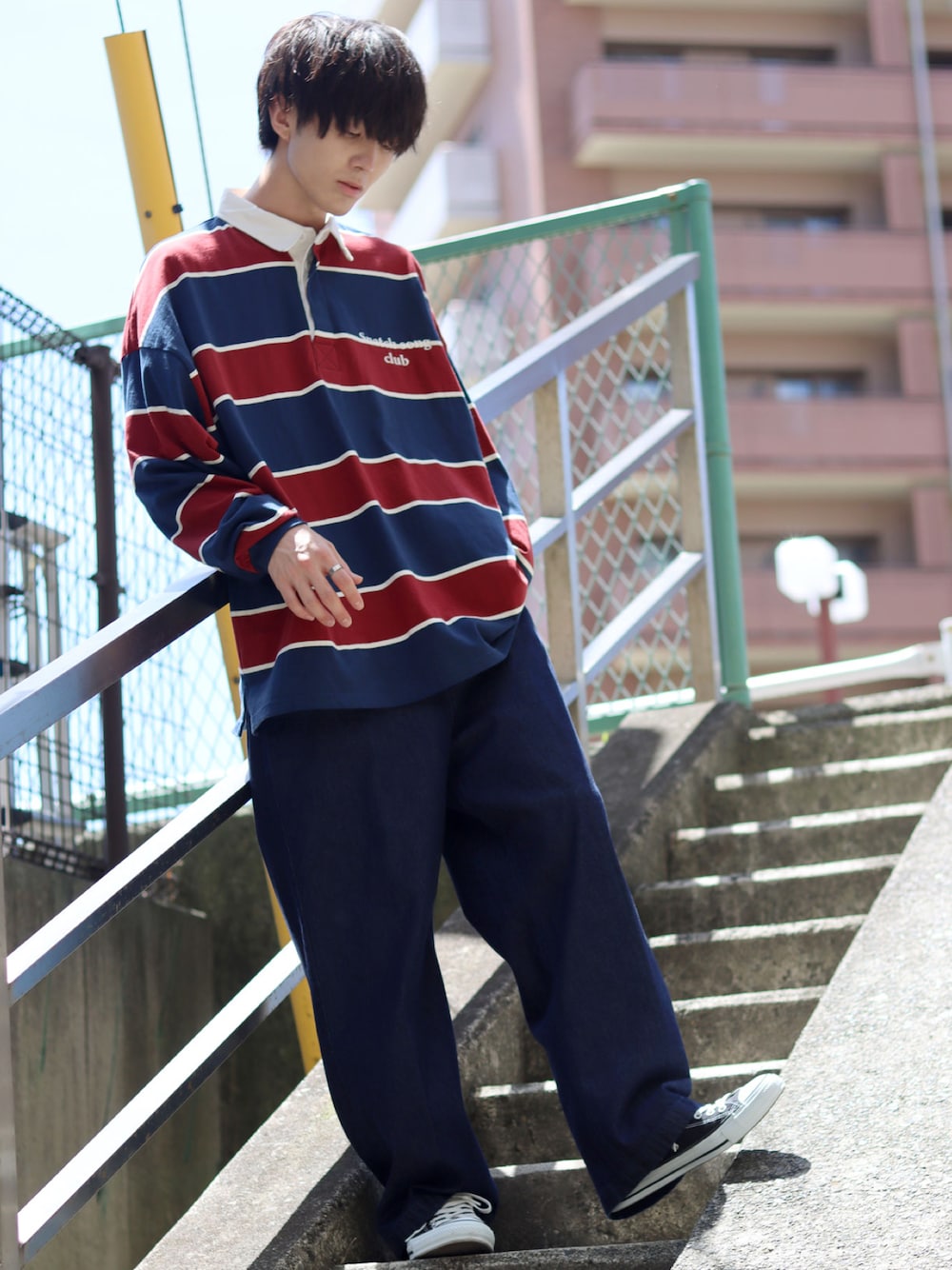 ブルー系のポロシャツ、ブルー系のチノパンツ、ブラック系のスニーカーを着用したメンズの夏コーディネートの1枚目の写真