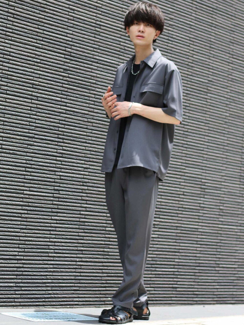 ブラック系のTシャツ/カットソー、グレー系のセットアップ、シルバー系のネックレスを着用したメンズの夏コーディネートの1枚目の写真