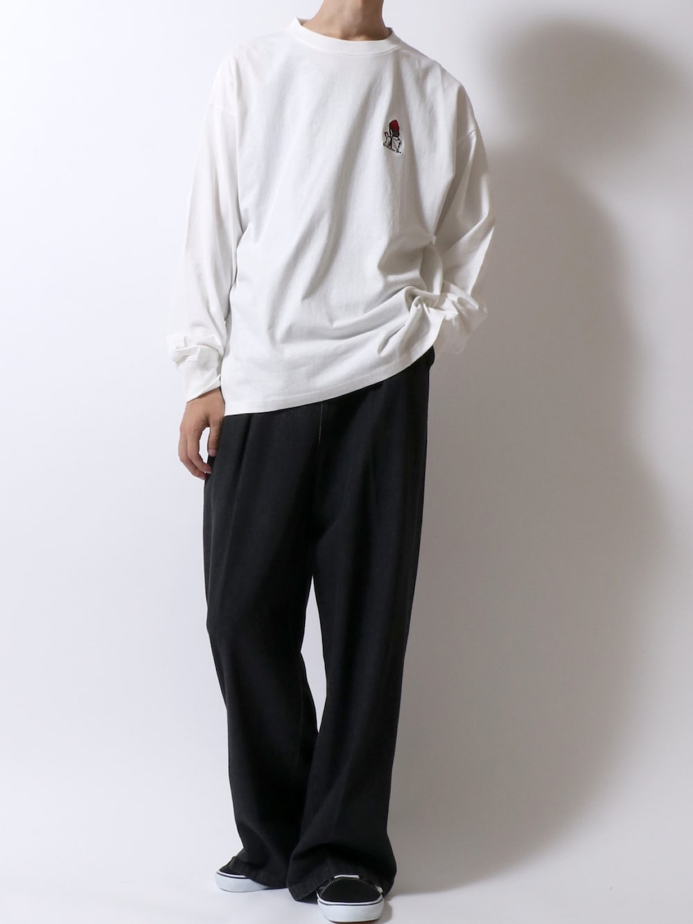 ホワイト系のTシャツ/カットソー、ブラック系のデニムパンツ、ブラック系のスニーカーを着用したメンズの秋コーディネートの1枚目の写真