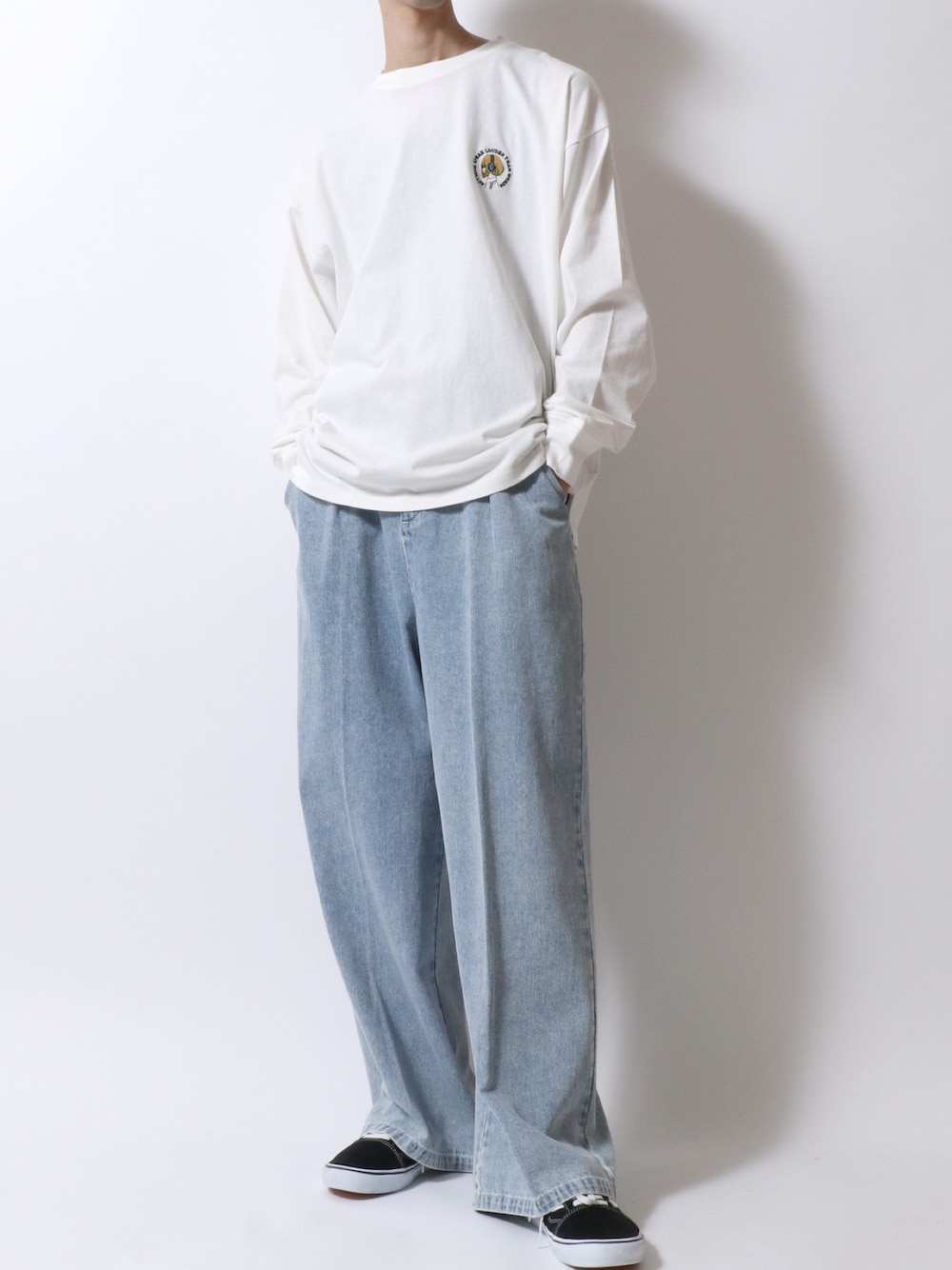 ホワイト系のTシャツ/カットソー、ブルー系のデニムパンツ、ブラック系のスニーカーを着用したメンズの秋コーディネートの1枚目の写真