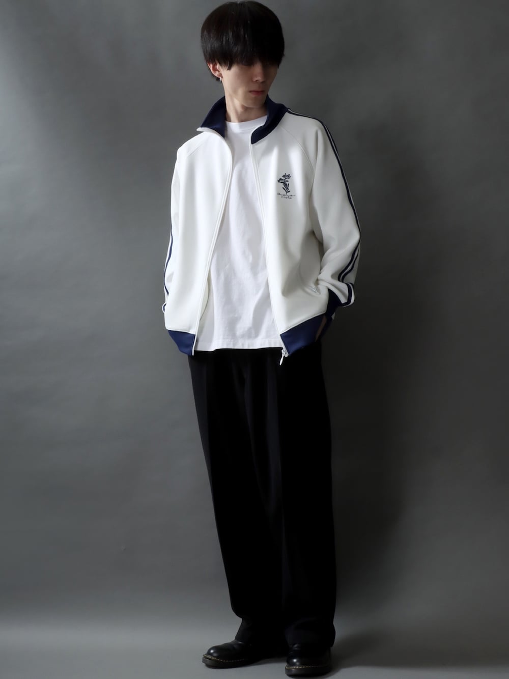 ホワイト系のジャージ、ホワイト系のTシャツ/カットソー、ブラック系のスラックスを着用したメンズの春コーディネートの1枚目の写真