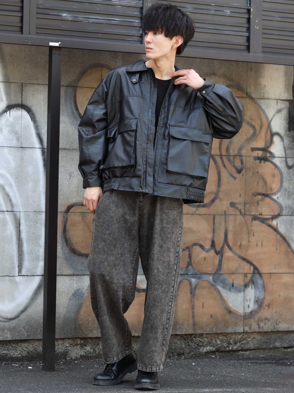 ブラック系のデニムパンツ、ブラック系のTシャツ/カットソー、ブラック系のミリタリージャケットを着用したメンズの春コーディネートの1枚目の写真