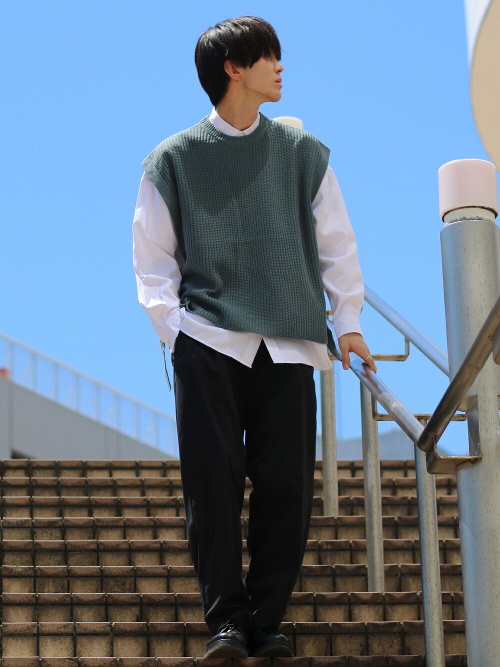 ブルー系のベスト、ホワイト系のシャツ/ブラウス、ブラック系のスラックスを着用したメンズの秋コーディネートの1枚目の写真