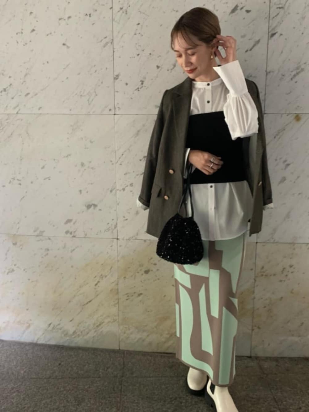 ブラック系のビジネスバッグ、ブラウン系のテーラードジャケット、ホワイト系のシャツ/ブラウスを着用したレディースの夏コーディネートの1枚目の写真