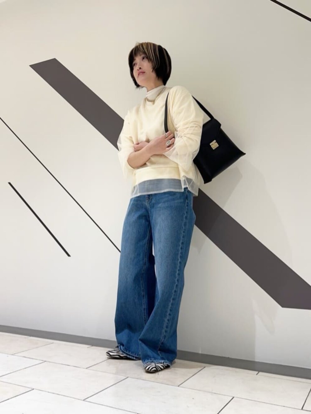ブラック系のショルダーバッグ、ホワイト系のTシャツ/カットソー、ホワイト系のスウェットを着用したレディースの冬コーディネートの1枚目の写真