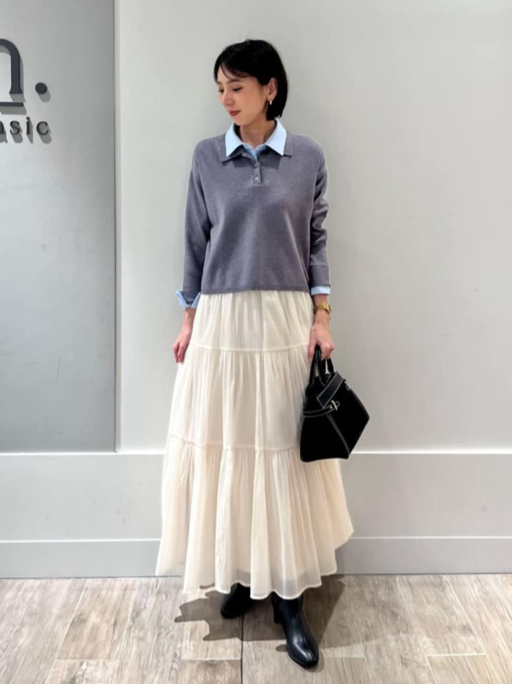ホワイト系のスカート、グレー系のニット/セーターを着用したレディースの冬コーディネートの1枚目の写真