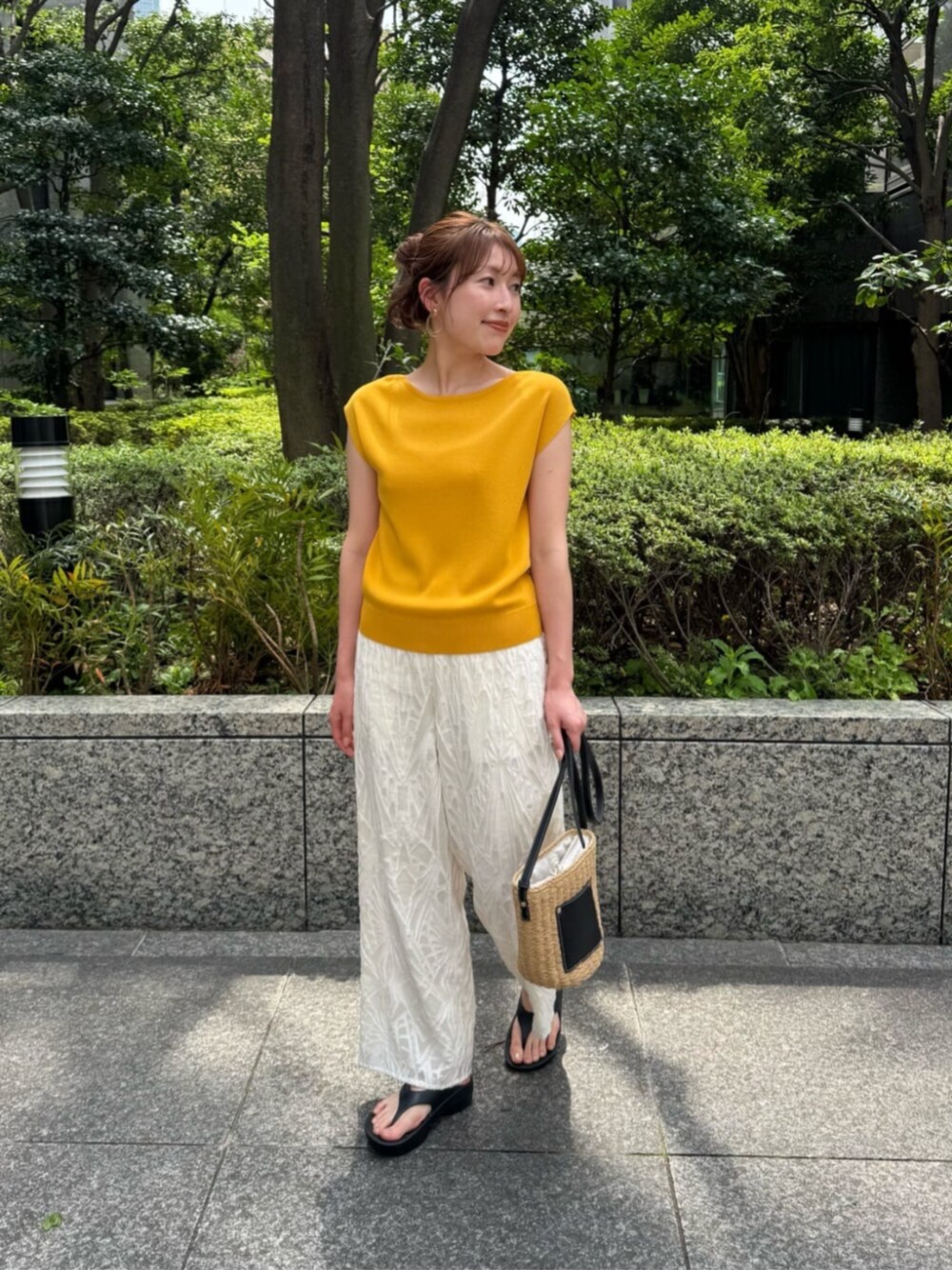 イエロー系のニット/セーター、ホワイト系のその他パンツを着用したレディースの春コーディネートの1枚目の写真