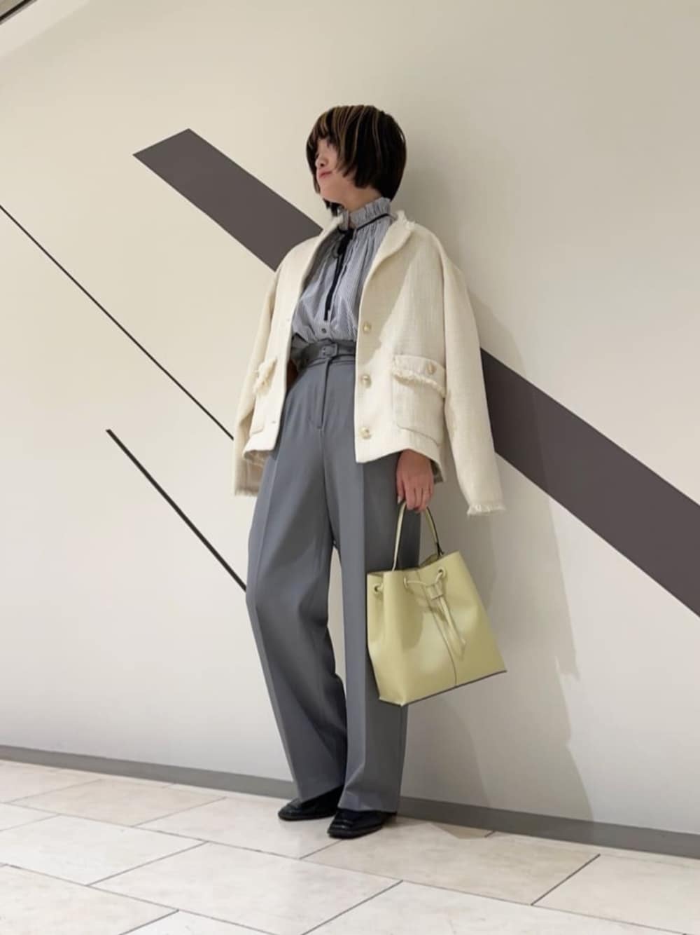 グレー系のシャツ/ブラウス、グレー系のスラックス、ホワイト系のノーカラージャケットを着用したレディースの春コーディネートの1枚目の写真