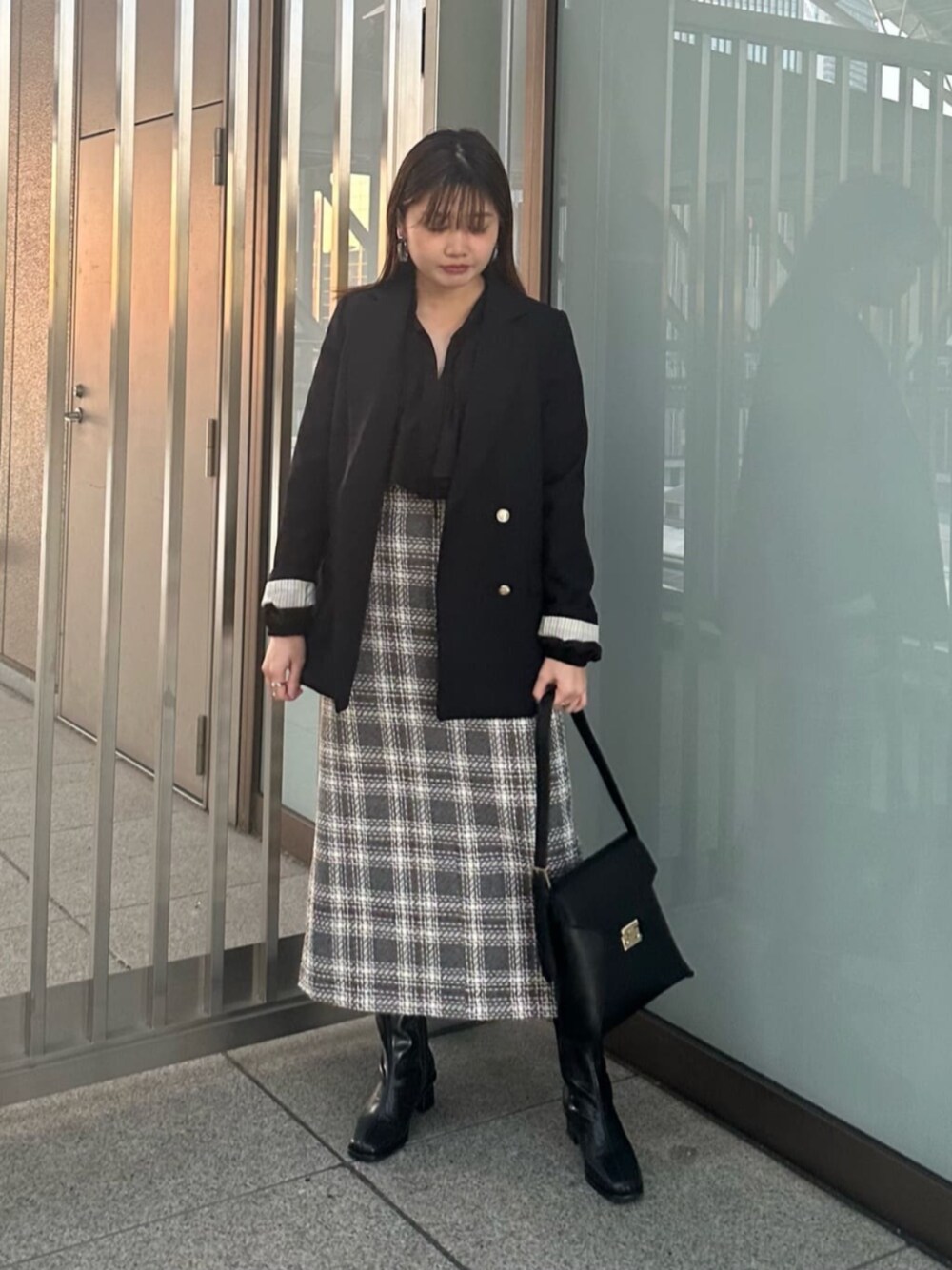 ブラック系のショルダーバッグ、ブラック系のブーツ、ブラック系のスカートを着用したレディースの秋コーディネートの1枚目の写真