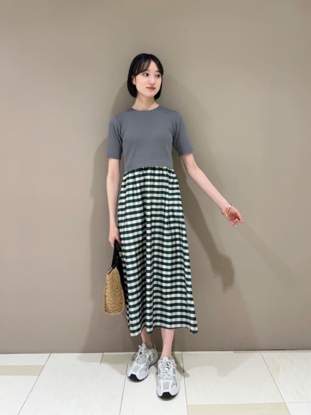 ブラック系のショルダーバッグ、グリーン系のワンピースを着用したレディースの夏コーディネートの1枚目の写真