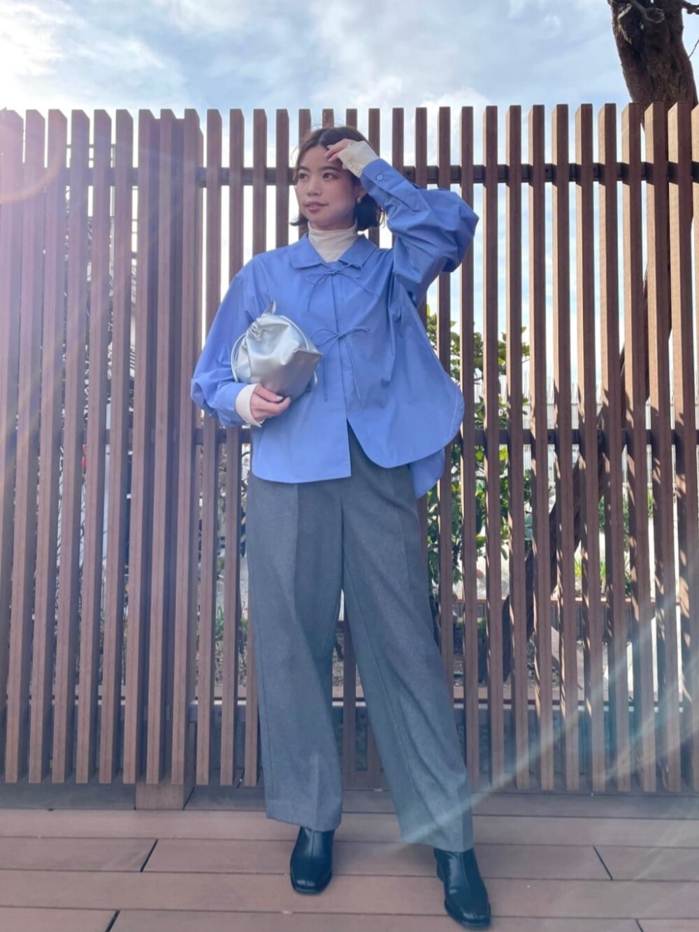 ブラック系のブーツ、ホワイト系のTシャツ/カットソー、シルバー系のビジネスバッグを着用したレディースの冬コーディネートの1枚目の写真