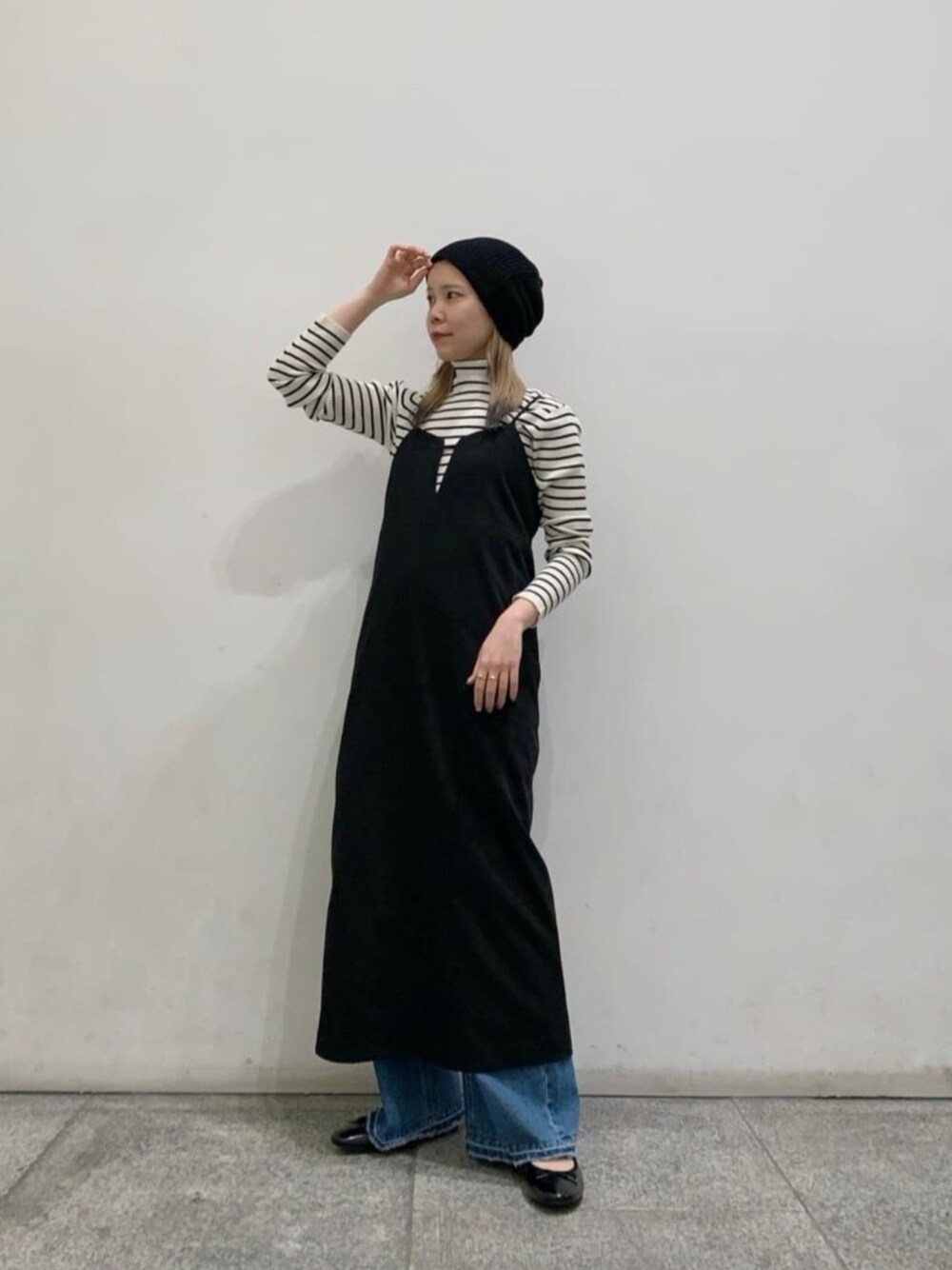 ホワイト系のニット/セーター、ブルー系のデニムパンツ、ブラック系のパンプスを着用したレディースの春コーディネートの1枚目の写真