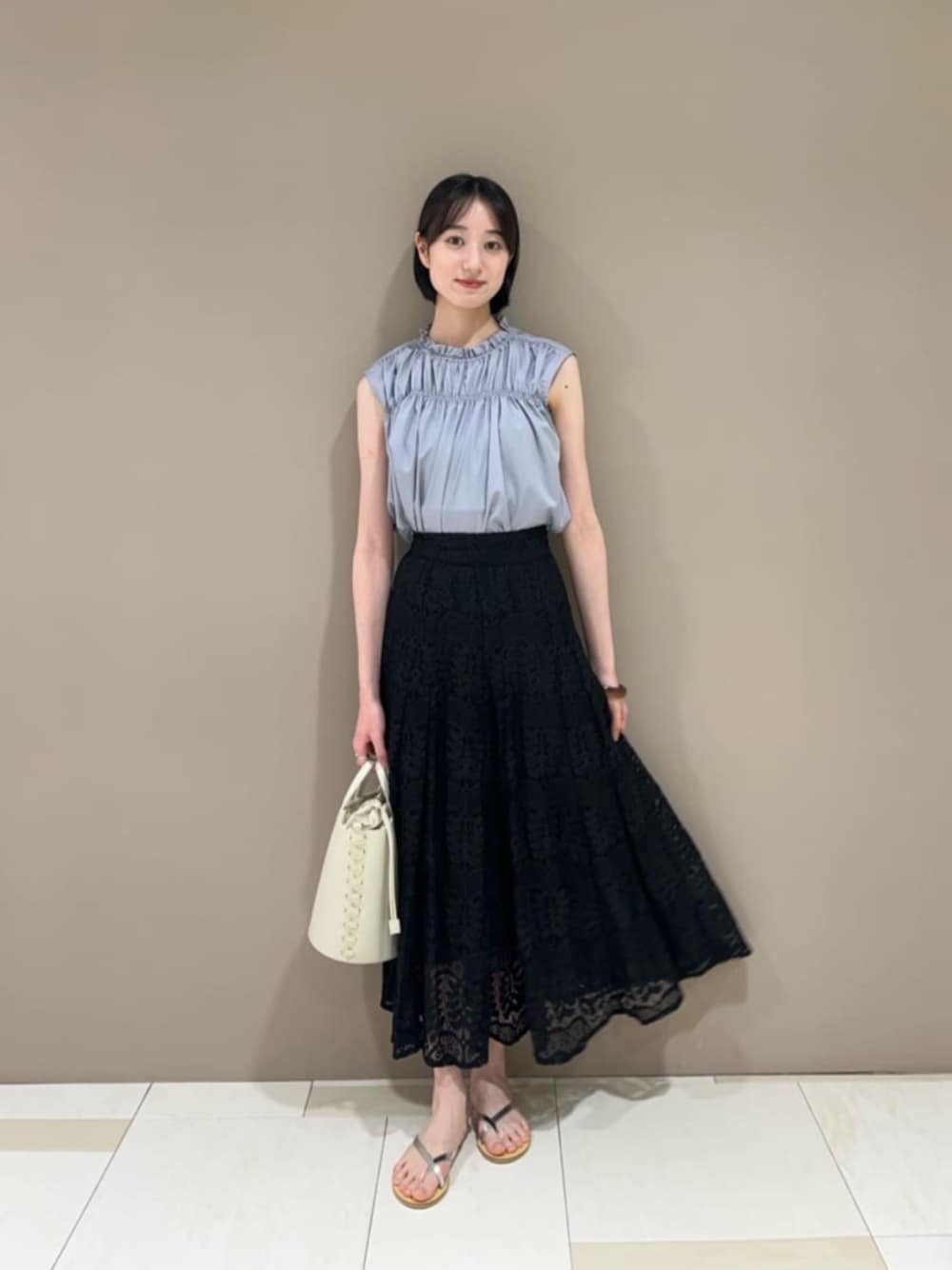 シルバー系のサンダル、グレー系のシャツ/ブラウス、ブラック系のスカートを着用したレディースの夏コーディネートの1枚目の写真