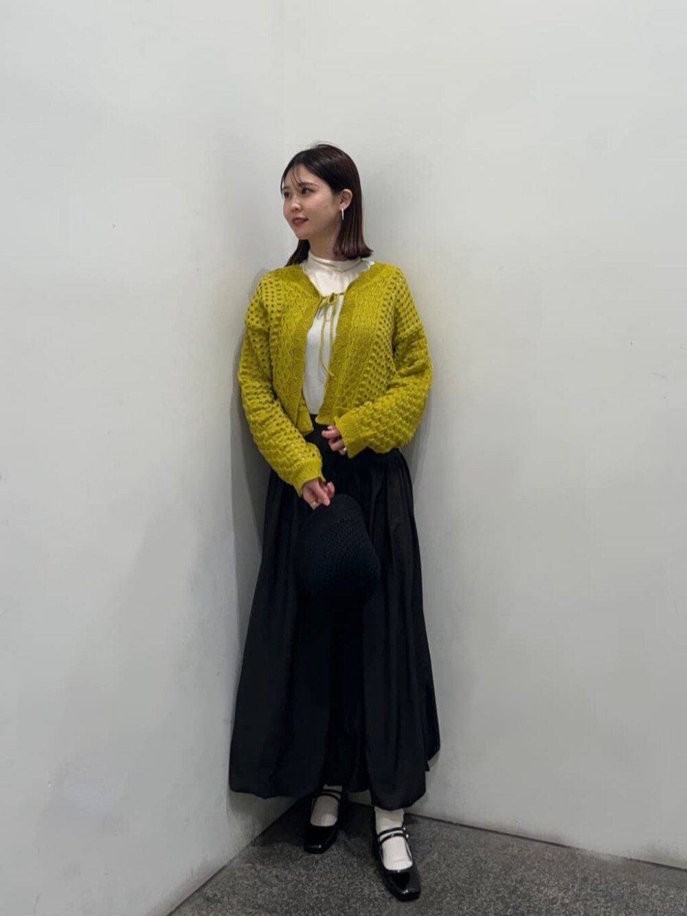 ホワイト系のTシャツ/カットソー、ブラック系のパンプス、ブラック系のスカートを着用したレディースの冬コーディネートの1枚目の写真