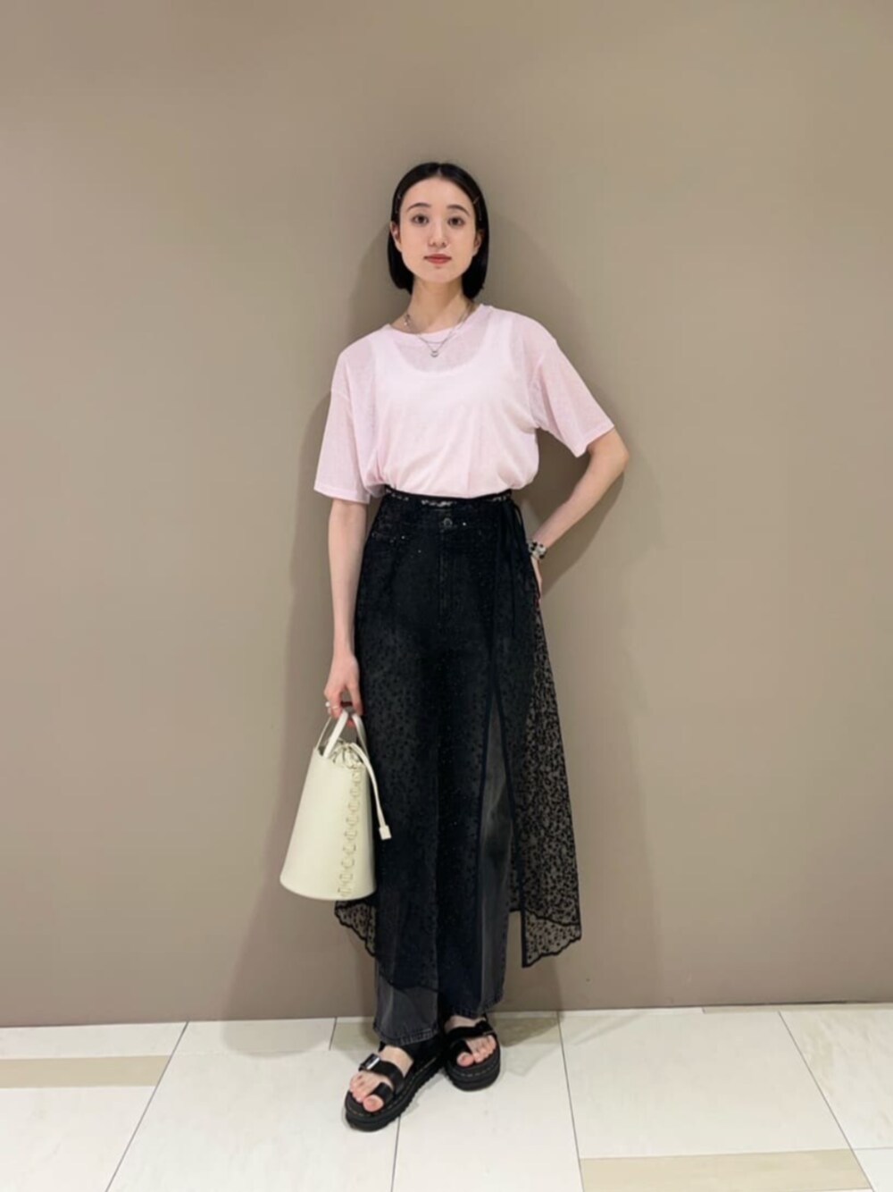 ブラック系のスカート、ピンク系のTシャツ/カットソー、ブラック系のデニムパンツを着用したレディースの夏コーディネートの1枚目の写真