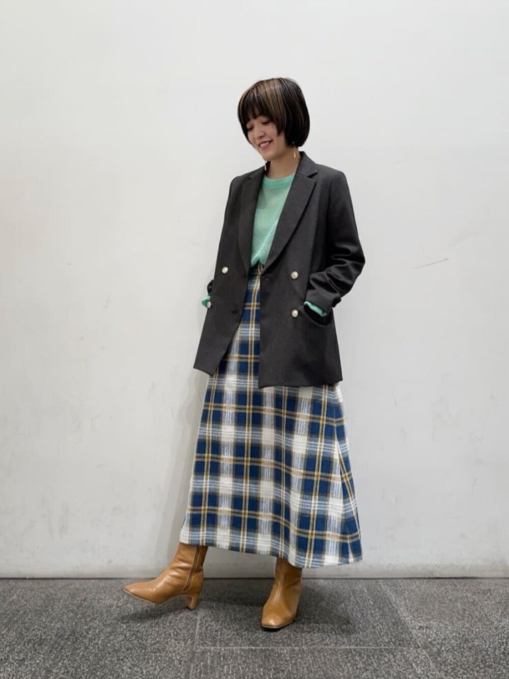 ベージュ系のブーツ、グリーン系のニット/セーター、グレー系のテーラードジャケットを着用したレディースの秋コーディネートの1枚目の写真