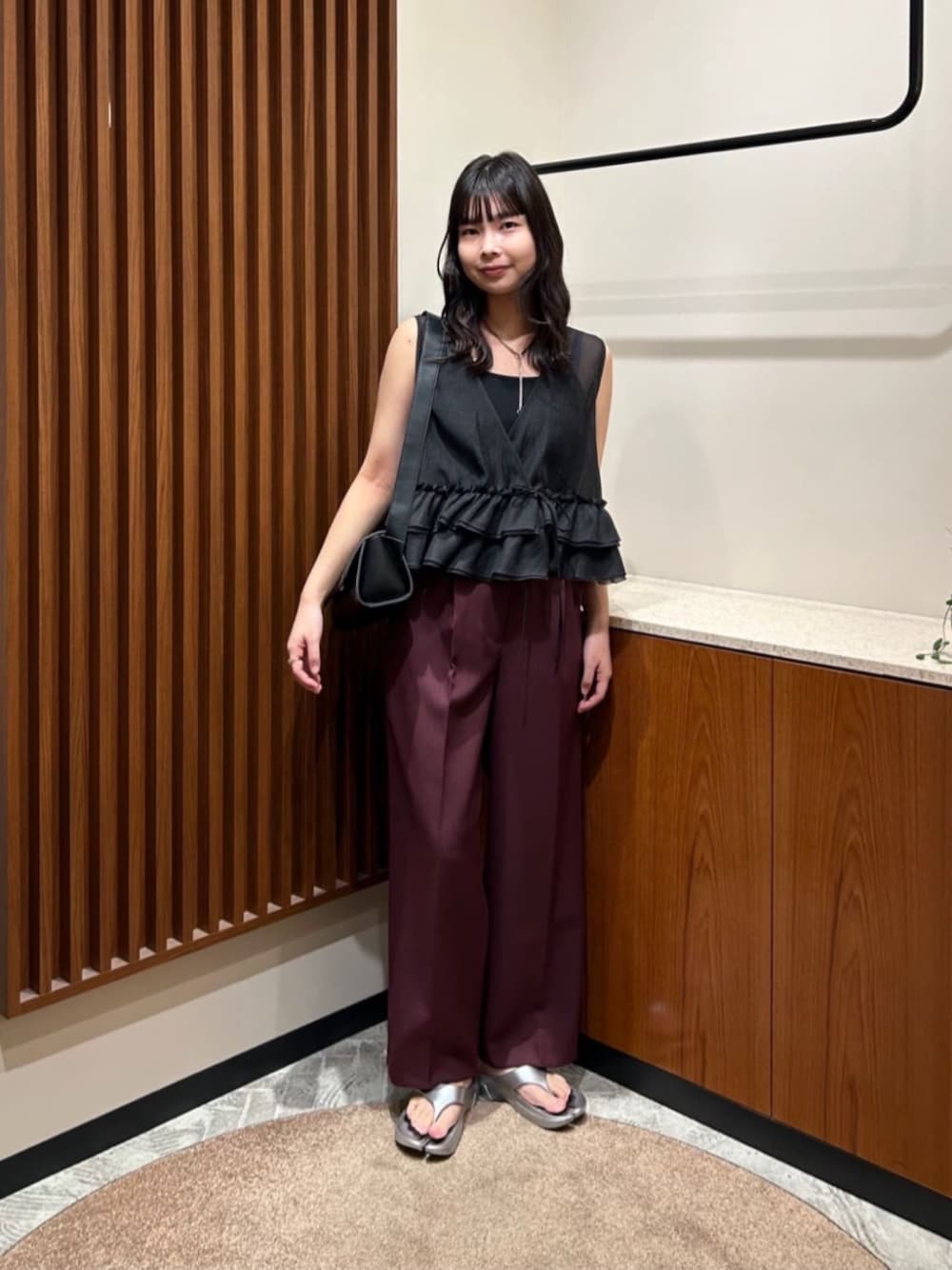 ブラック系のショルダーバッグ、ブラック系のベスト、レッド系のその他パンツを着用したレディースの夏コーディネートの1枚目の写真