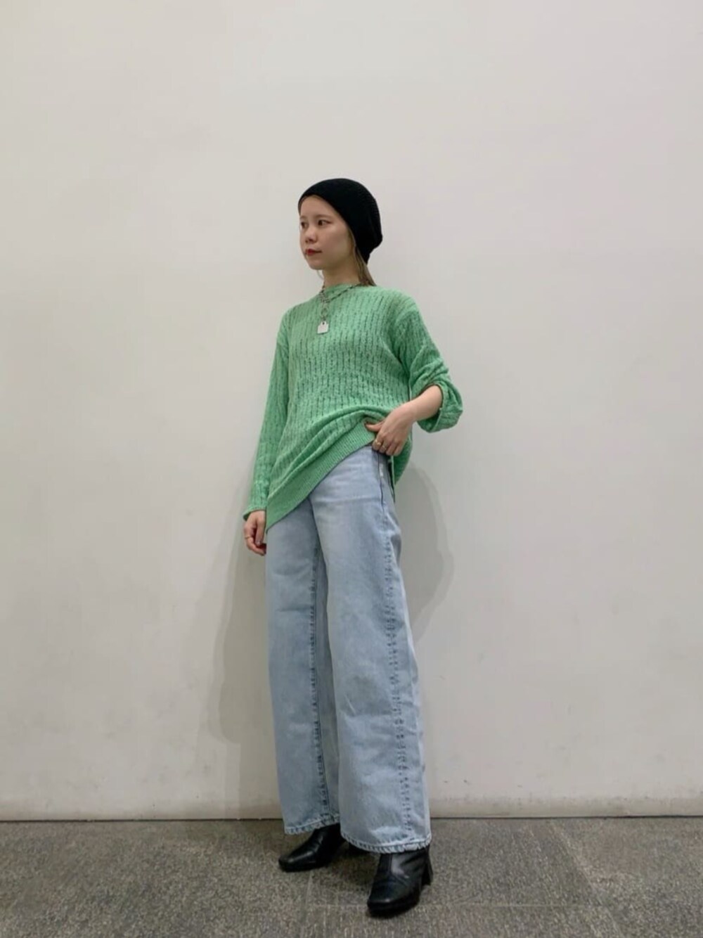 ブルー系のデニムパンツ、グリーン系のニット/セーターを着用したレディースの冬コーディネートの1枚目の写真