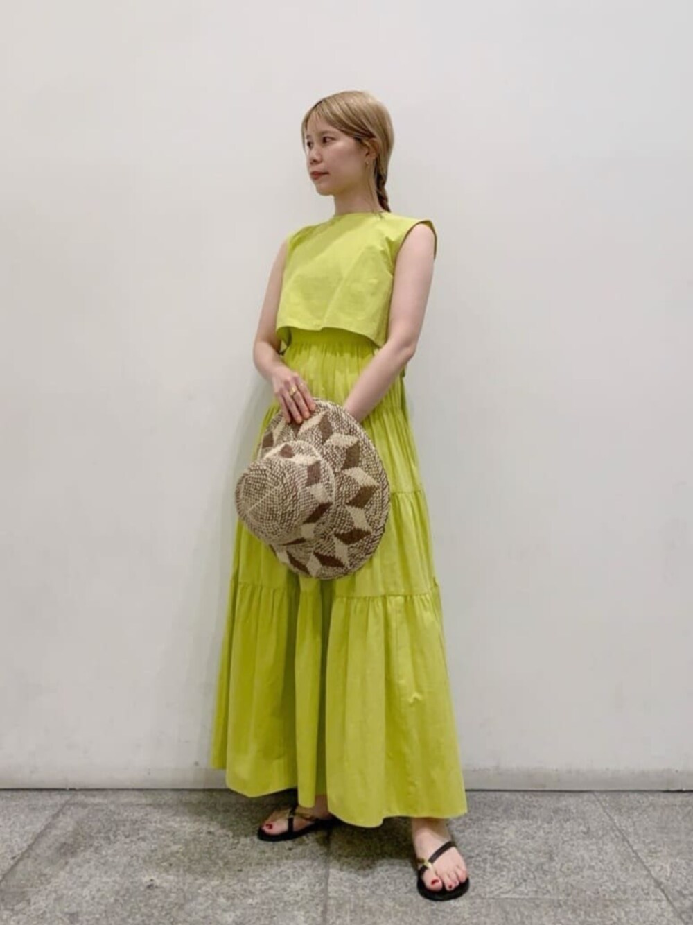 ゴールド系のサンダル、イエロー系のワンピース、ブラウン系のハットを着用したレディースの夏コーディネートの1枚目の写真