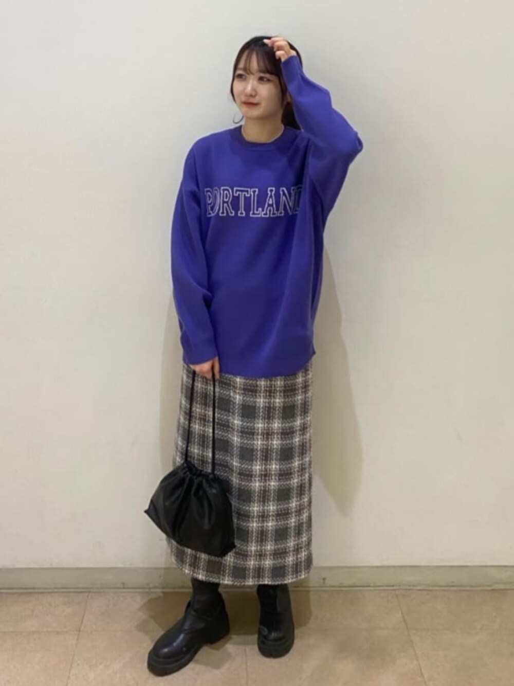 ブラック系のビジネスバッグ、パープル系のニット/セーター、グレー系のスカートを着用したレディースの秋コーディネートの1枚目の写真