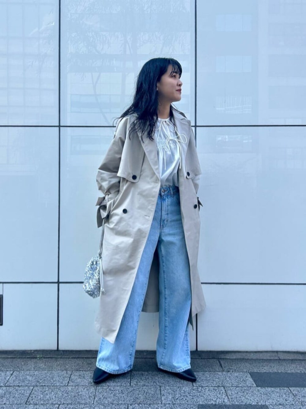 シルバー系のショルダーバッグ、ブルー系のデニムパンツ、ホワイト系のシャツ/ブラウスを着用したレディースの冬コーディネートの1枚目の写真