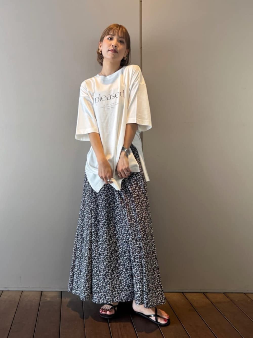 ブラック系のスカート、ホワイト系のTシャツ/カットソーを着用したレディースの夏コーディネートの1枚目の写真