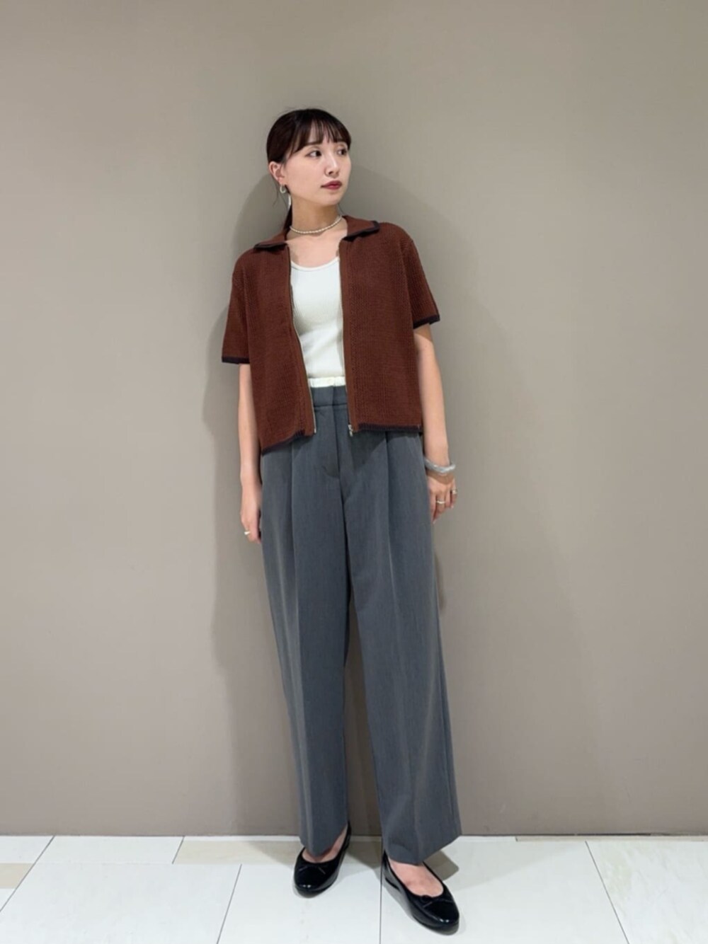 ブラック系のパンプス、グレー系のスラックス、ホワイト系のタンクトップを着用したレディースの夏コーディネートの1枚目の写真