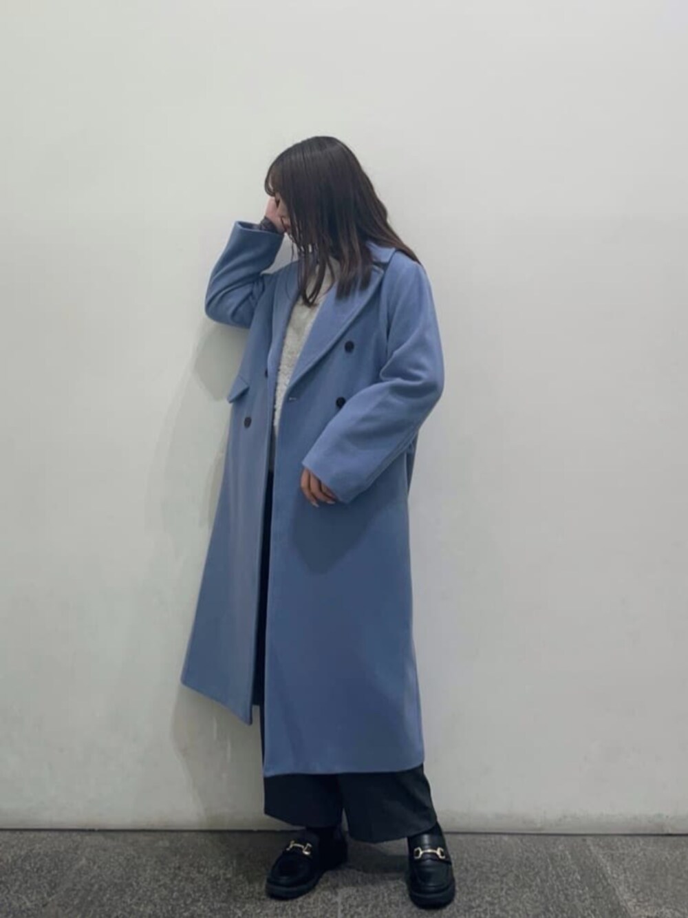 グレー系のニット/セーター、グレー系のTシャツ/カットソー、グレー系のスラックスを着用したレディースの冬コーディネートの1枚目の写真