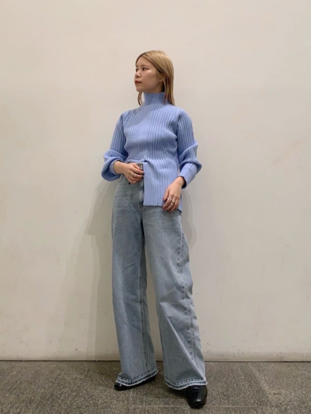 ブラック系のブーツ、ブルー系のニット/セーター、ブルー系のデニムパンツを着用したレディースの冬コーディネートの1枚目の写真