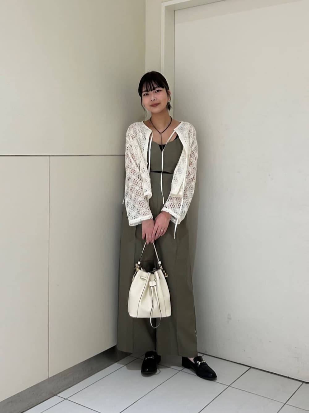 ホワイト系のショルダーバッグ、ホワイト系のシャツ/ブラウス、ブラウン系のサロペット/オーバーオールを着用したレディースの春コーディネートの1枚目の写真