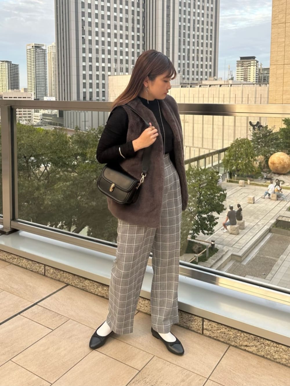 グレー系のベスト、グレー系のスラックス、ブラック系のTシャツ/カットソーを着用したレディースの秋コーディネートの1枚目の写真