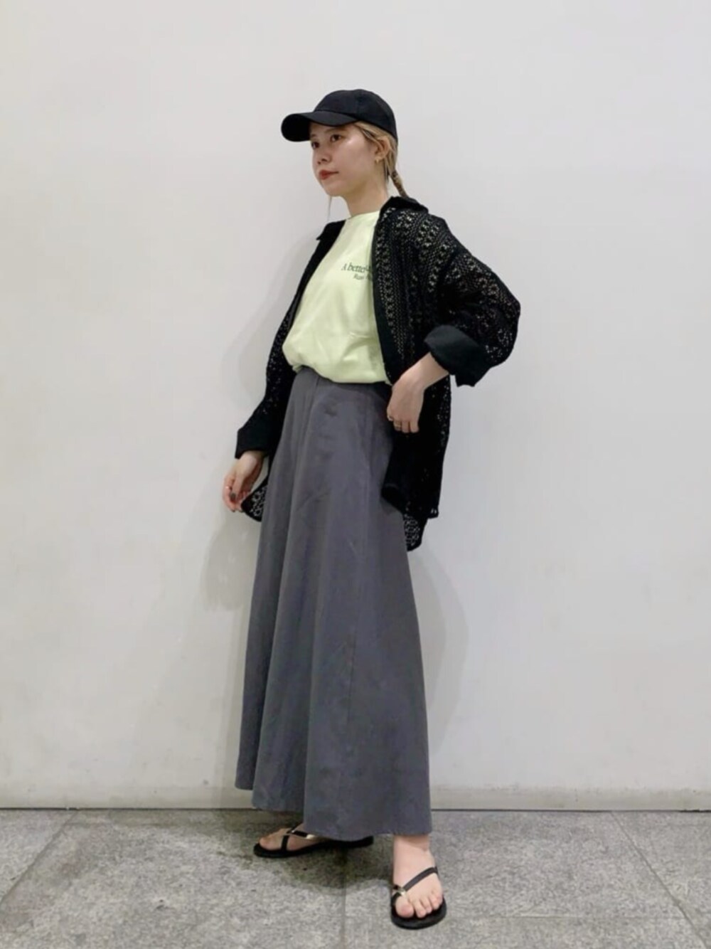 ブラック系のシャツ/ブラウス、イエロー系のTシャツ/カットソー、グレー系のスカートを着用したレディースの春コーディネートの1枚目の写真