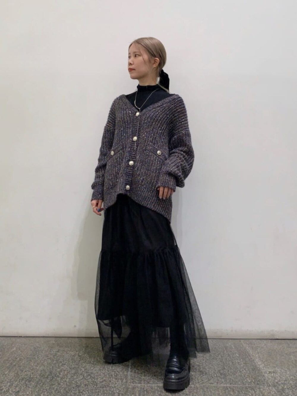 ブラック系のTシャツ/カットソー、ブルー系のカーディガン/ボレロ、ブラック系のスカートを着用したレディースの秋コーディネートの1枚目の写真