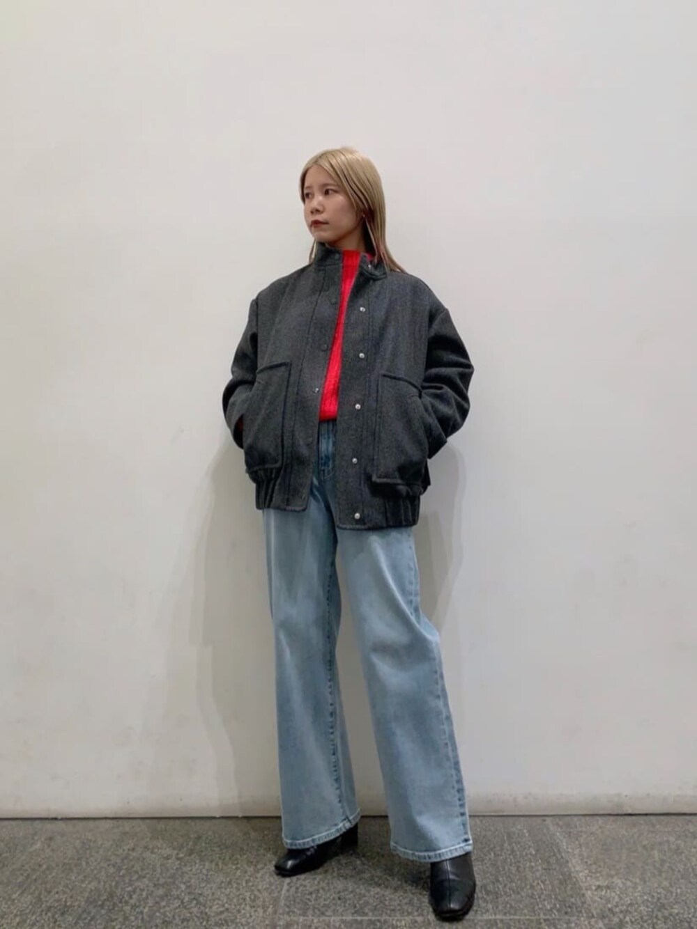 ブルー系のデニムパンツ、ブラック系のブーツ、グレー系のブルゾンを着用したレディースの冬コーディネートの1枚目の写真