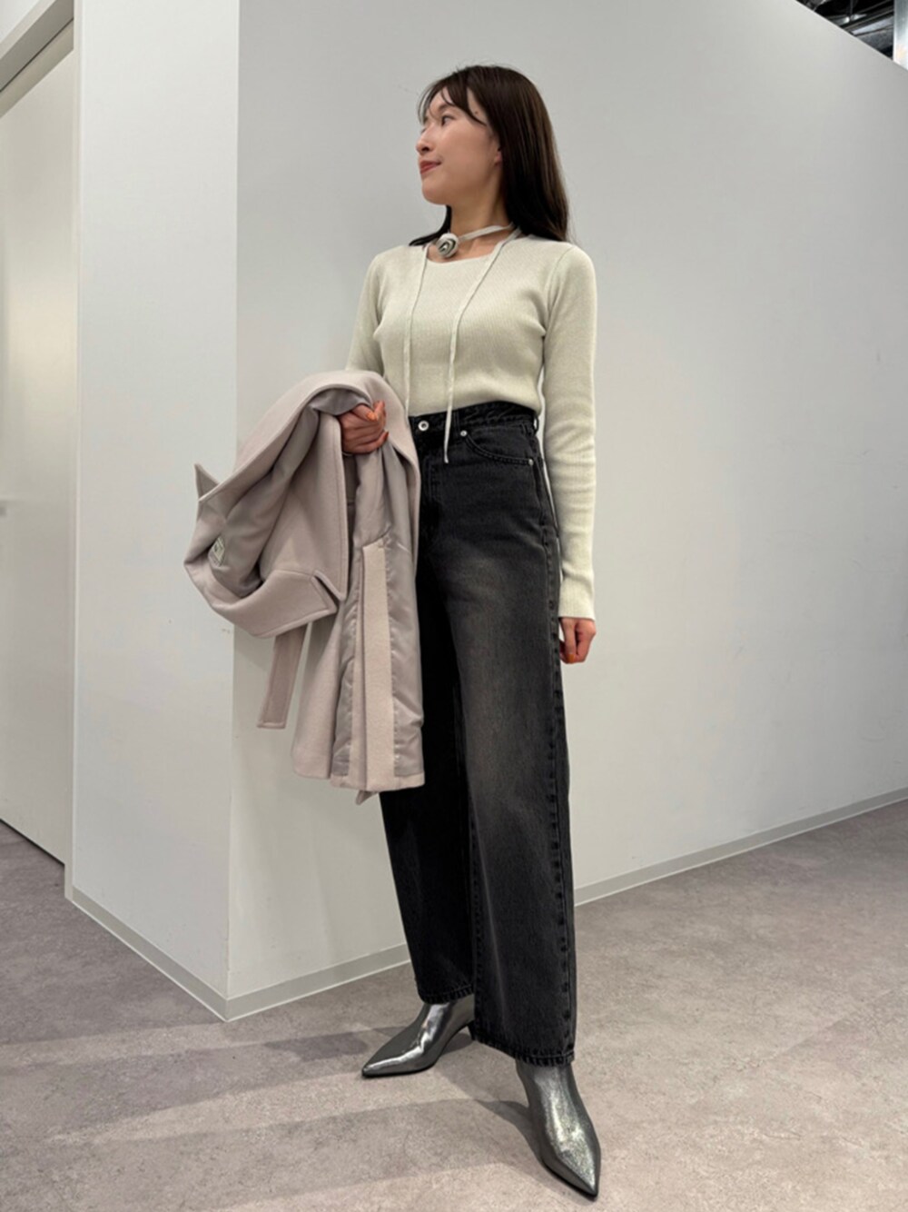 ブラック系のデニムパンツ、ホワイト系のニット/セーター、ベージュ系のその他アウターを着用したレディースの秋コーディネートの1枚目の写真