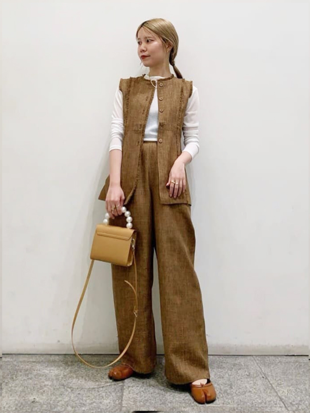 ホワイト系のTシャツ/カットソー、ベージュ系のショルダーバッグ、ベージュ系のセットアップを着用したレディースの春コーディネートの1枚目の写真