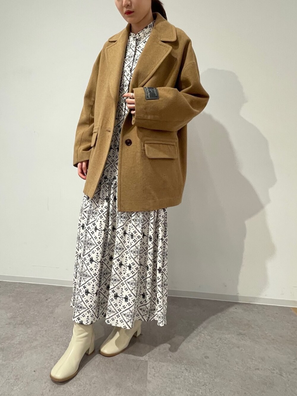 ブラウン系のその他アウター、ホワイト系のワンピースを着用したレディースの冬コーディネートの1枚目の写真