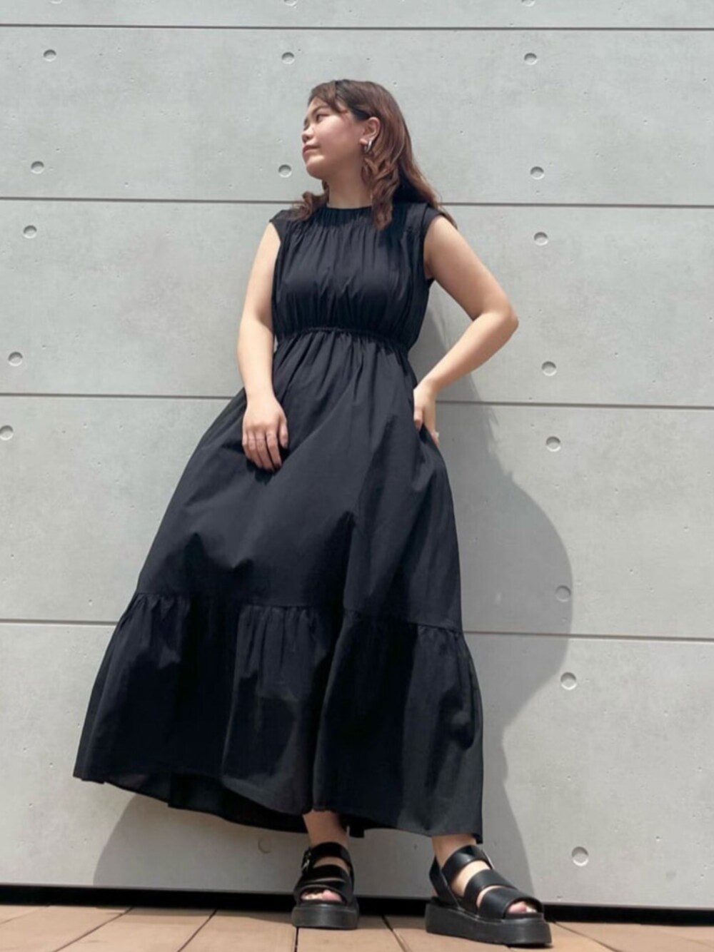 ブラック系のワンピースを着用したレディースの夏コーディネートの1枚目の写真