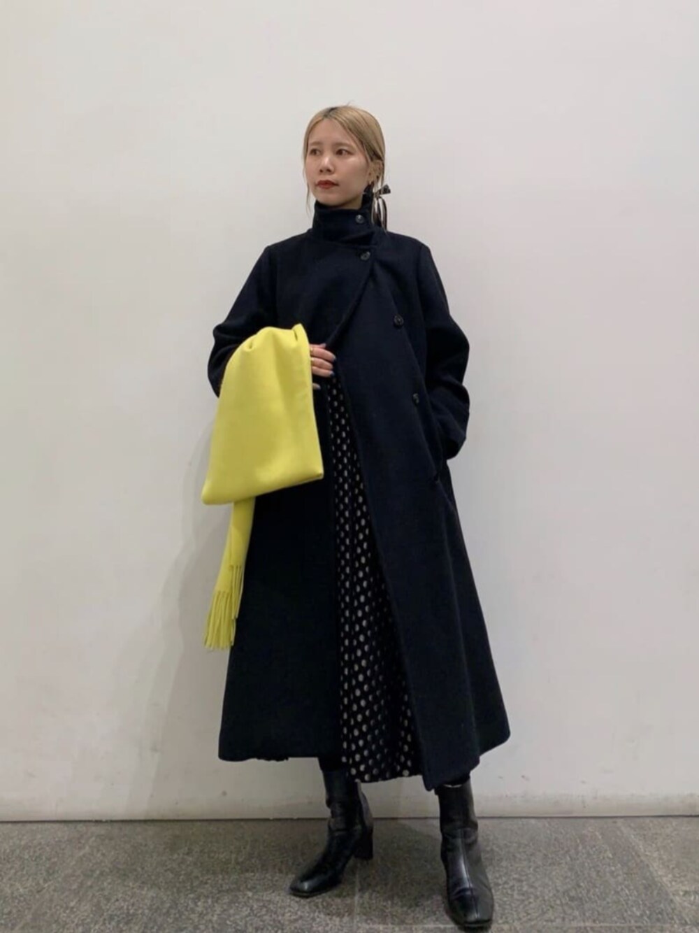 ブラック系のブーツ、ブラック系のTシャツ/カットソー、ブラック系のステンカラーコートを着用したレディースの冬コーディネートの1枚目の写真