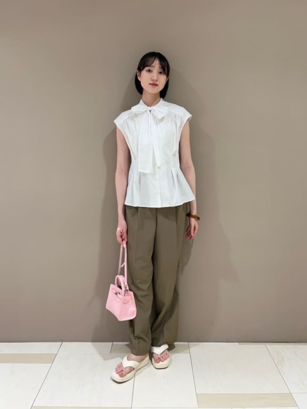 ホワイト系のサンダル、ピンク系のショルダーバッグ、ホワイト系のシャツ/ブラウスを着用したレディースの夏コーディネートの1枚目の写真