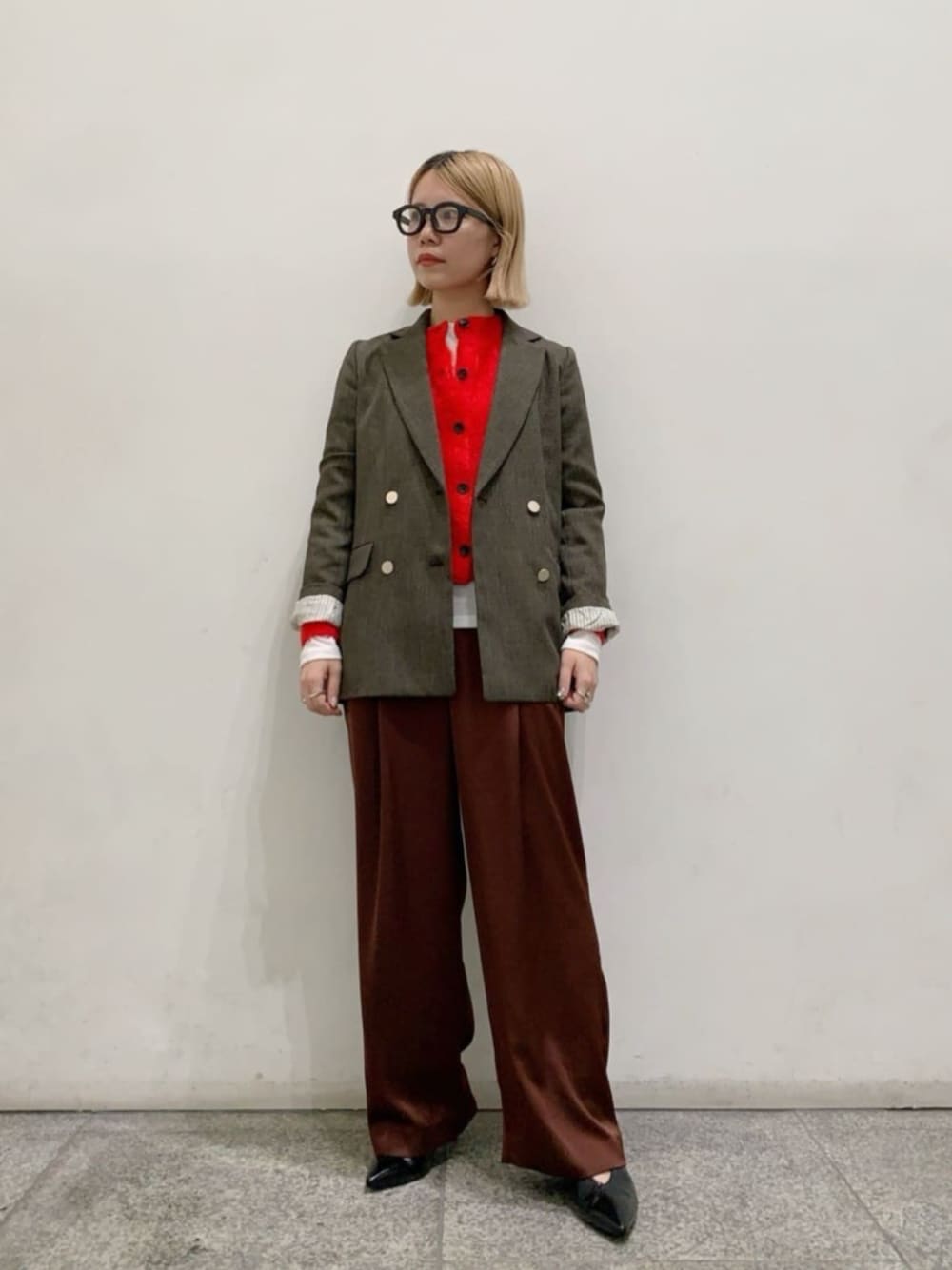 ブラック系のパンプス、レッド系のカーディガン/ボレロ、ホワイト系のTシャツ/カットソーを着用したレディースの秋コーディネートの1枚目の写真