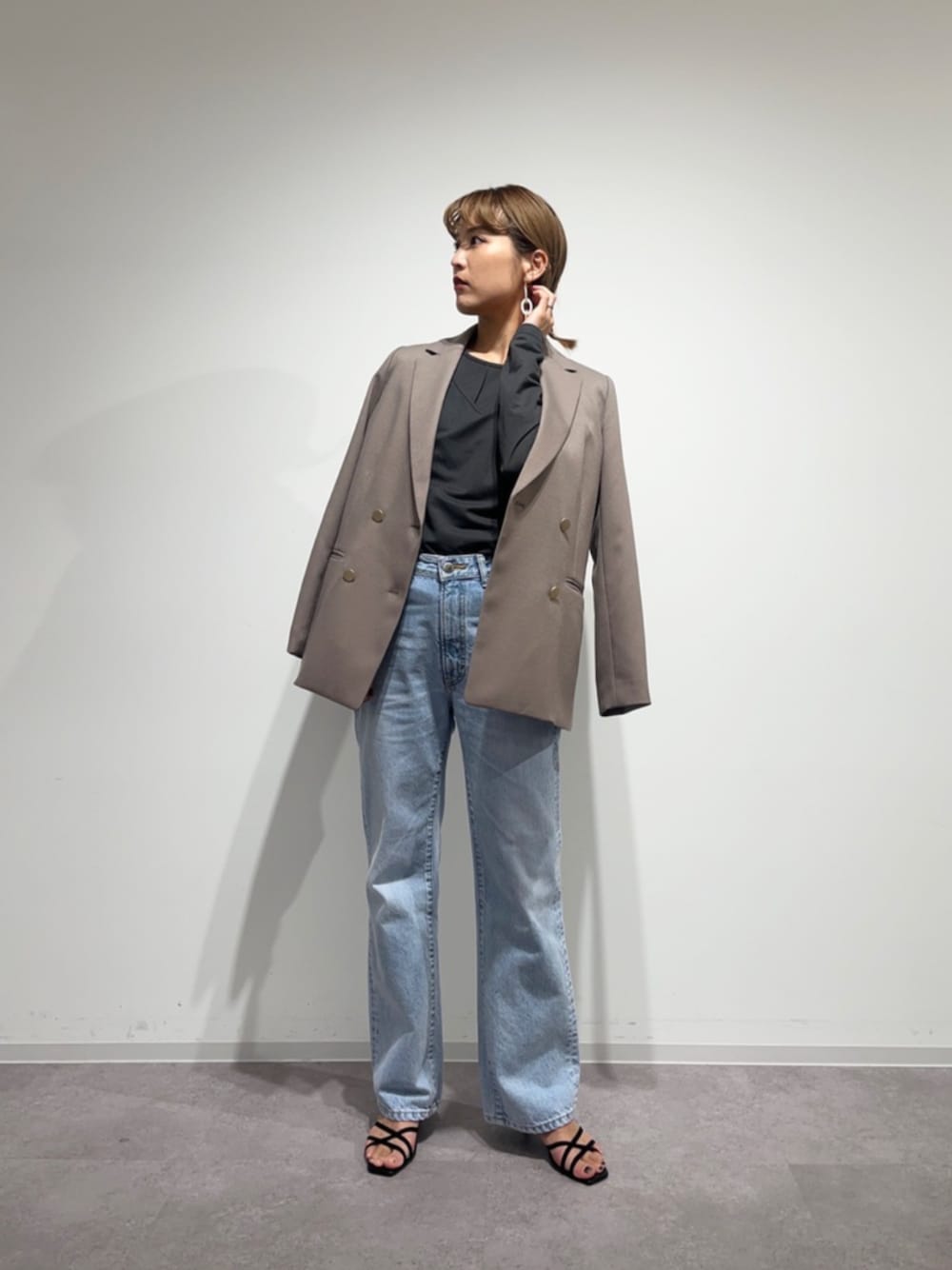 ブラウン系のテーラードジャケット、ブルー系のデニムパンツを着用したレディースの冬コーディネートの1枚目の写真