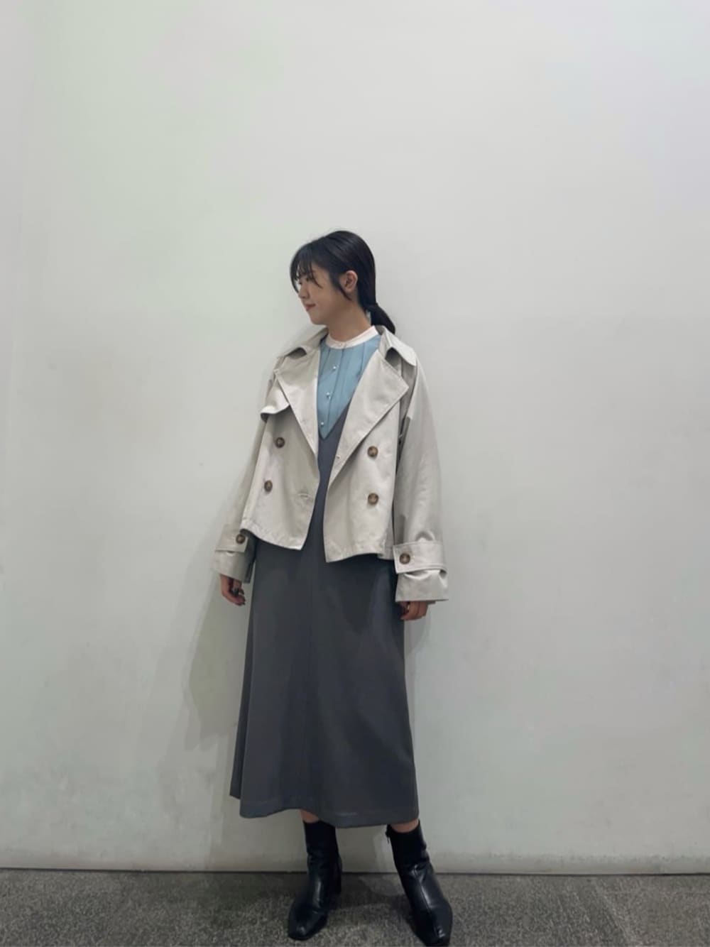 ブラック系のブーツ、ホワイト系のトレンチコート、ブルー系のシャツ/ブラウスを着用したレディースの冬コーディネートの1枚目の写真