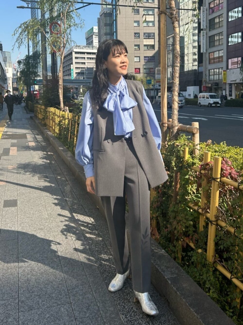 ブルー系のTシャツ/カットソー、グレー系のベスト、グレー系のスラックスを着用したレディースの冬コーディネートの1枚目の写真