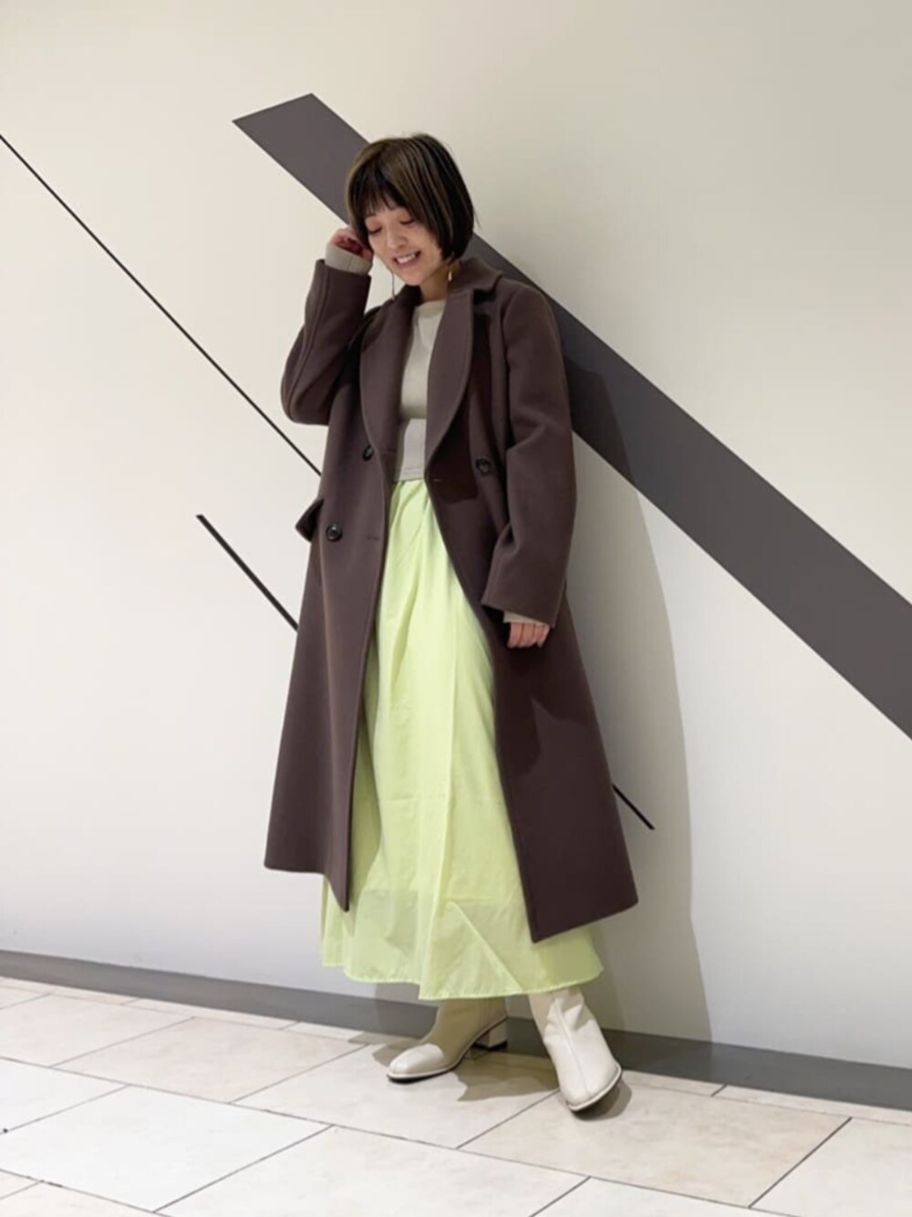 ホワイト系のブーツ、ブラック系のブーツ、ブラウン系のチェスターコートを着用したレディースの冬コーディネートの1枚目の写真