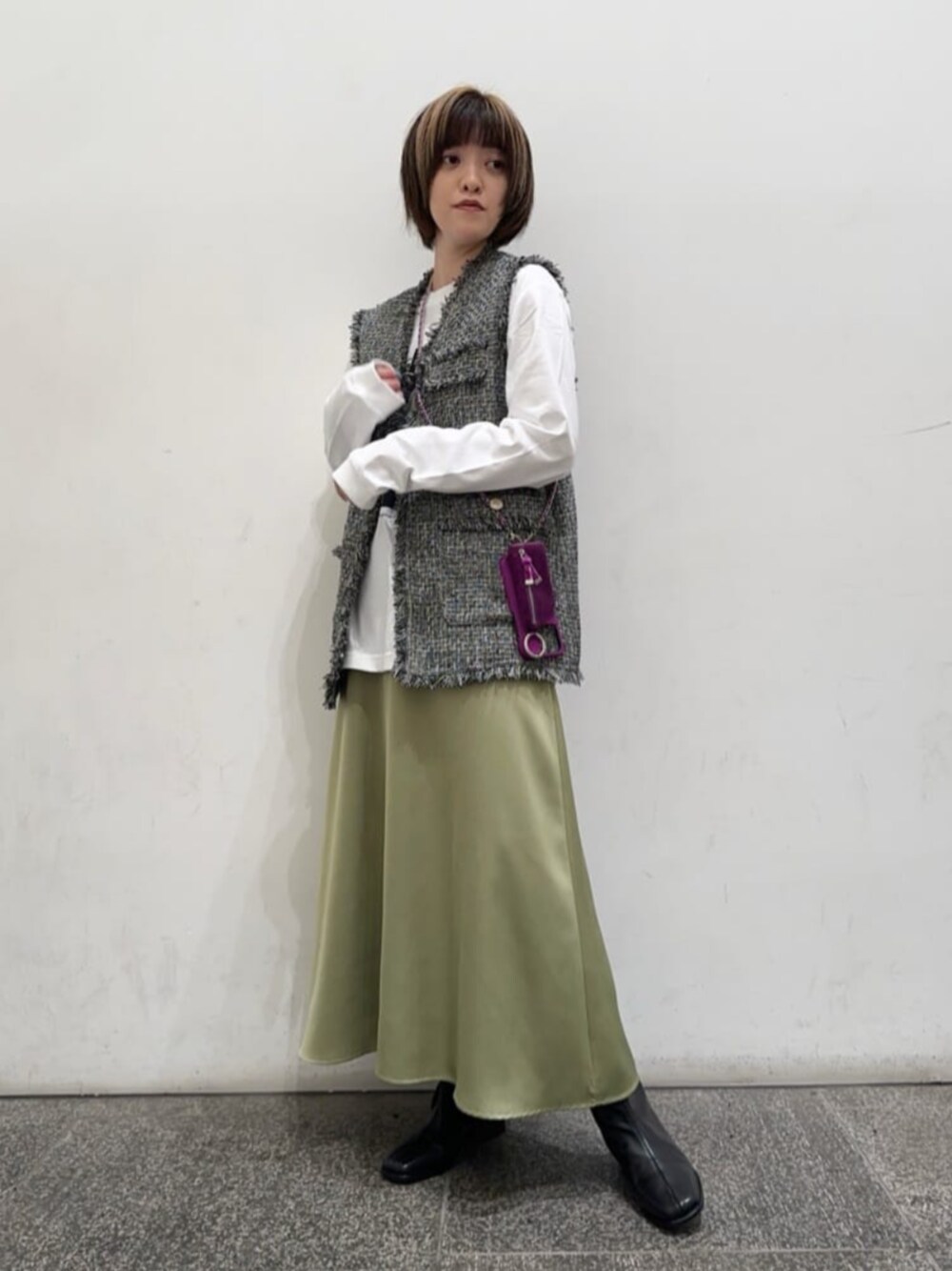 ブラック系のブーツ、グレー系のベスト、グリーン系のスカートを着用したレディースの秋コーディネートの1枚目の写真