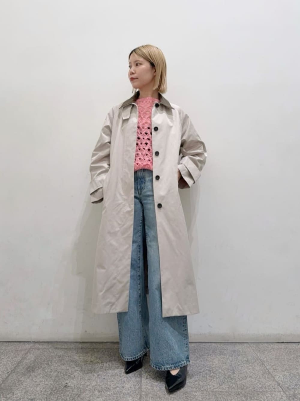 ブラック系のパンプス、ブルー系のデニムパンツ、ベージュ系のステンカラーコートを着用したレディースの冬コーディネートの1枚目の写真